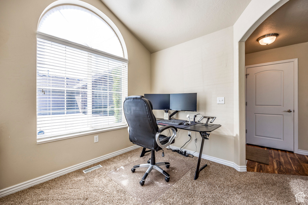 Office featuring vaulted ceiling and dark carpet