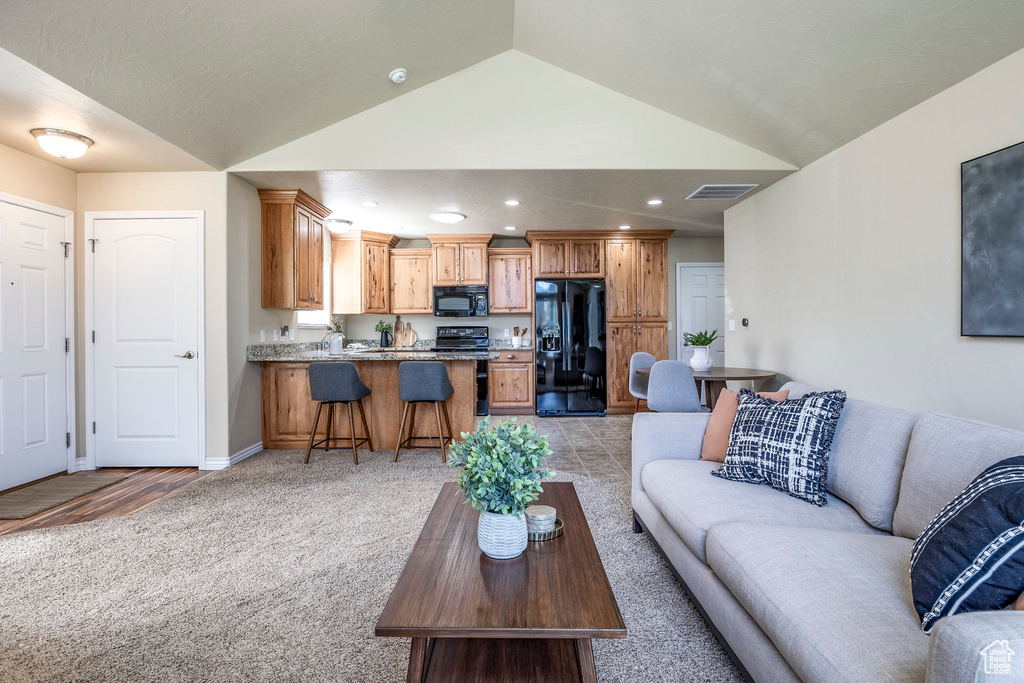 Living room with vaulted ceiling and light carpet