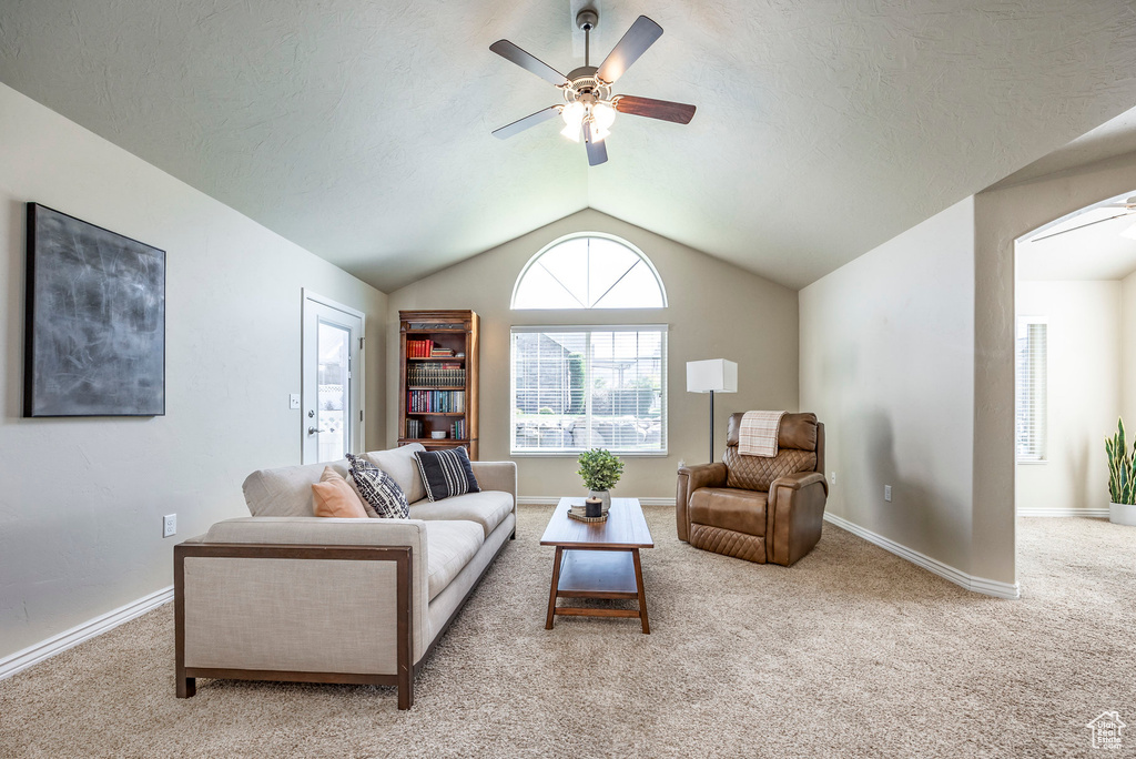 Carpeted living room featuring ceiling fan and lofted ceiling