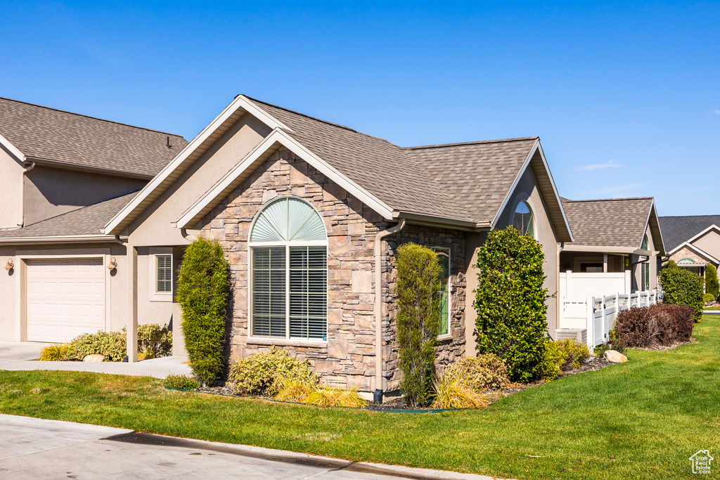 View of front of home featuring a front yard and a garage