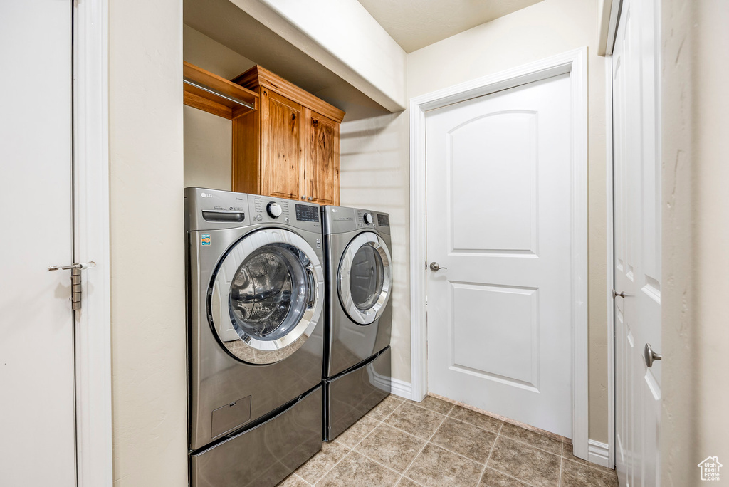 Washroom featuring cabinets and separate washer and dryer