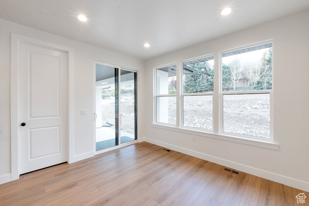 Spare room with light hardwood / wood-style floors and plenty of natural light