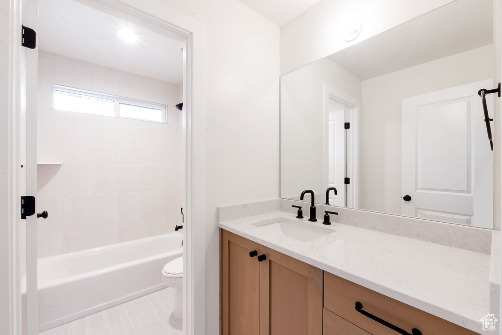 Full bathroom with vanity, toilet, and tiled shower / bath