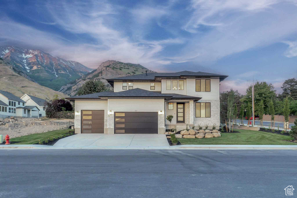 View of front of house with a garage, driveway, and a mountain view