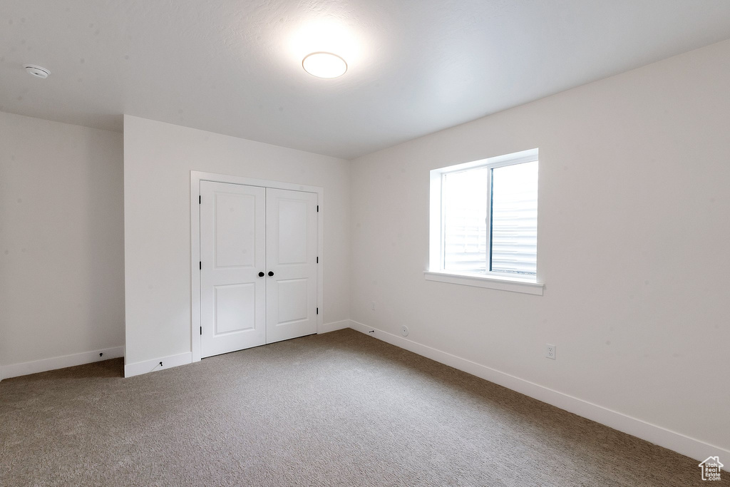 Unfurnished bedroom featuring carpet floors and a closet