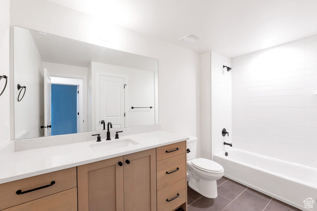 Full bathroom featuring vanity, toilet, tile patterned flooring, and tiled shower / bath