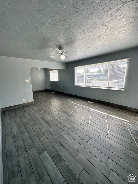 Unfurnished room featuring ceiling fan, hardwood / wood-style floors, and a textured ceiling