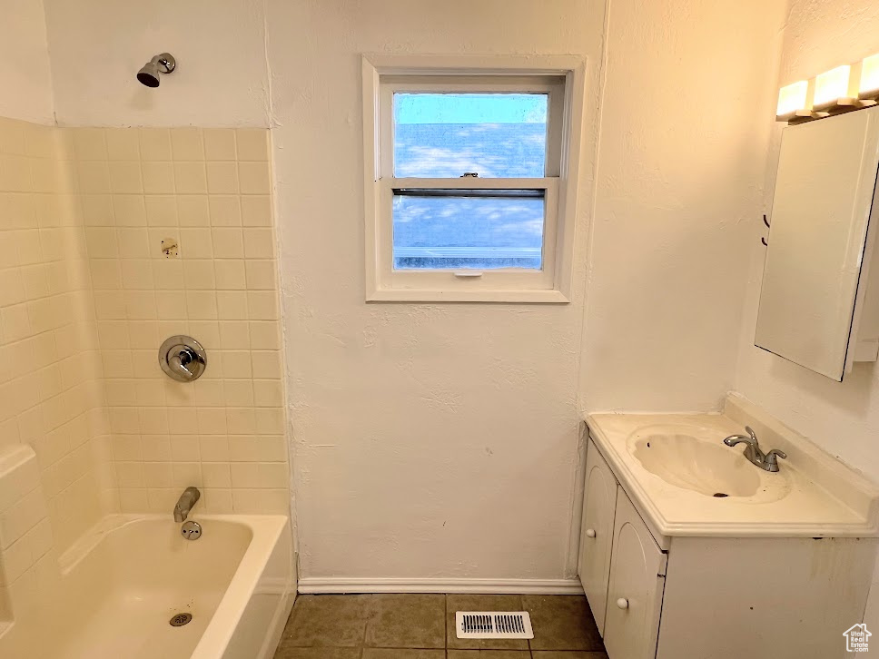 Bathroom with vanity, tiled shower / bath combo, and tile patterned flooring