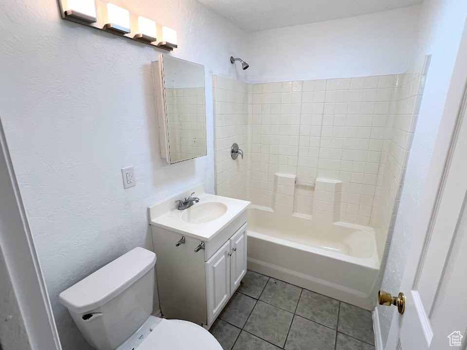 Full bathroom featuring tile patterned flooring, tiled shower / bath combo, vanity, and toilet