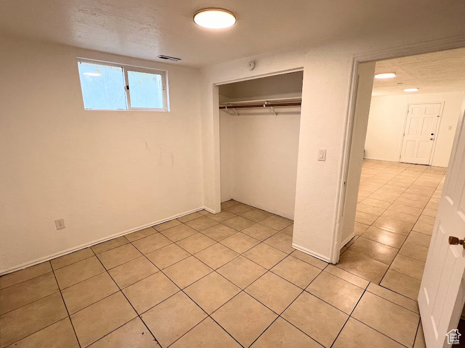 Unfurnished bedroom with a closet and light tile patterned floors