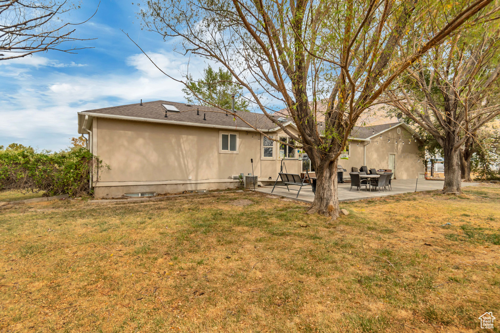 Back of property with a yard and a patio area