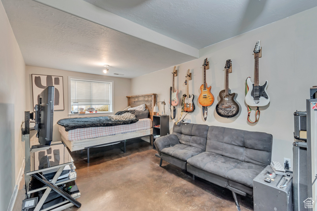 Bedroom featuring a textured ceiling and concrete flooring