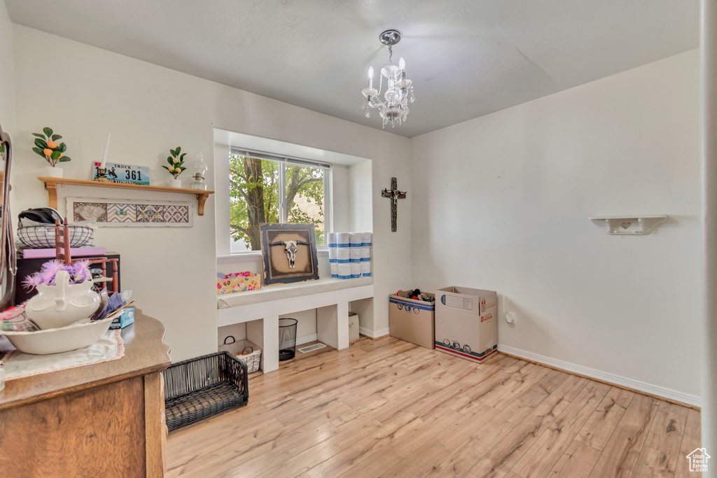 Miscellaneous room with hardwood / wood-style floors and a chandelier