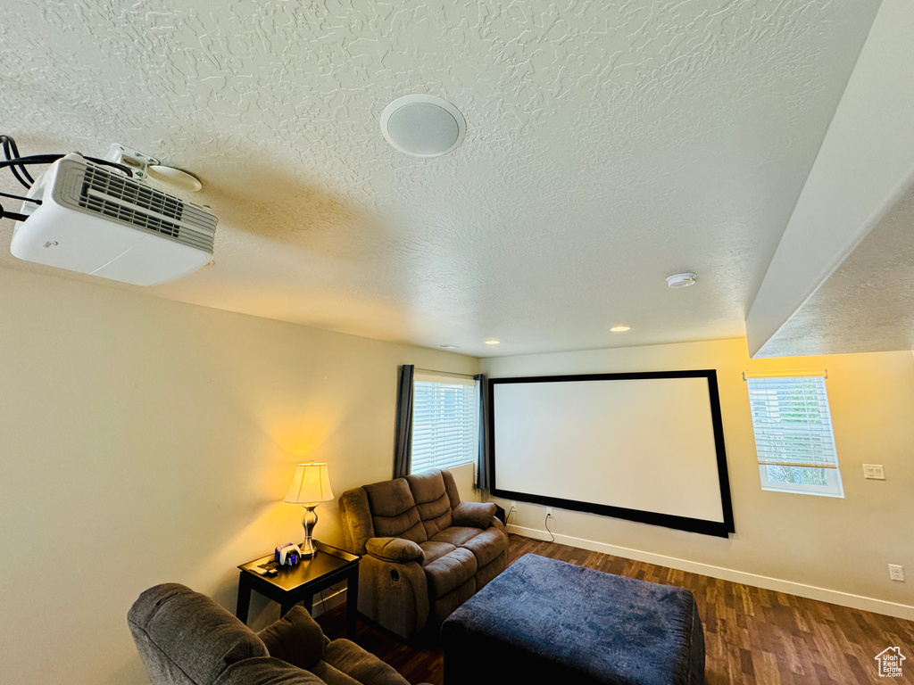 Cinema room featuring hardwood / wood-style floors and a textured ceiling