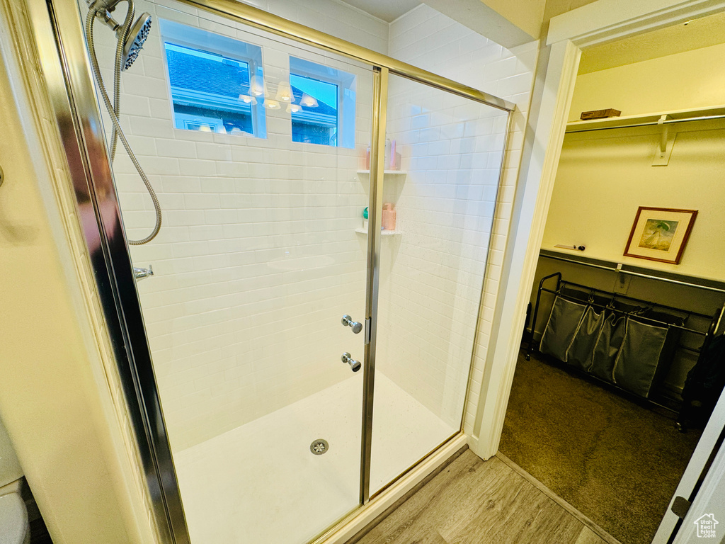 Bathroom with an enclosed shower and hardwood / wood-style floors