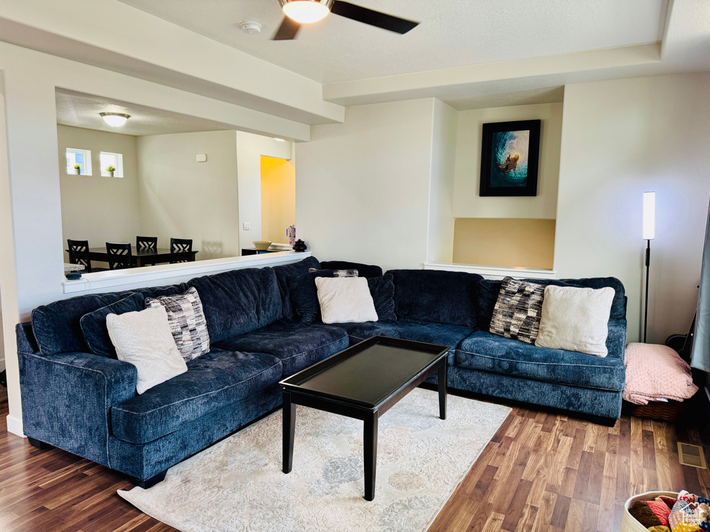 Living room with ceiling fan and hardwood / wood-style floors