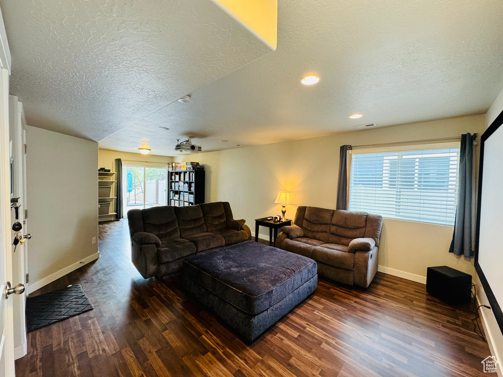 Living room with dark wood-type flooring and a textured ceiling