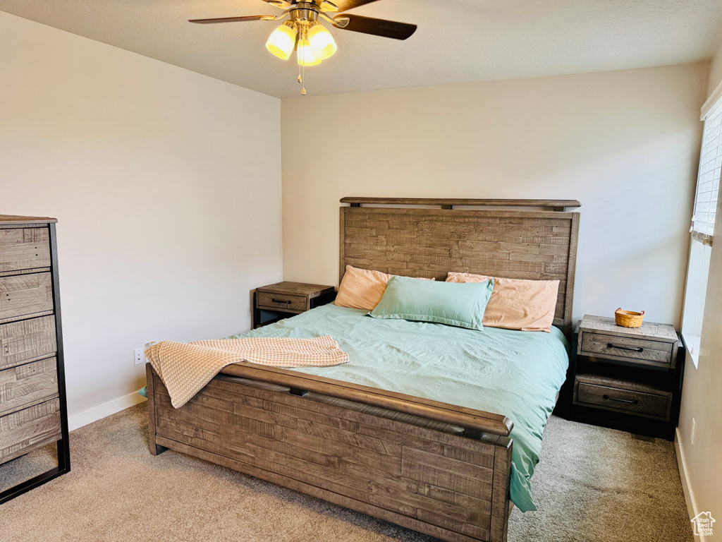 Bedroom with ceiling fan and light colored carpet