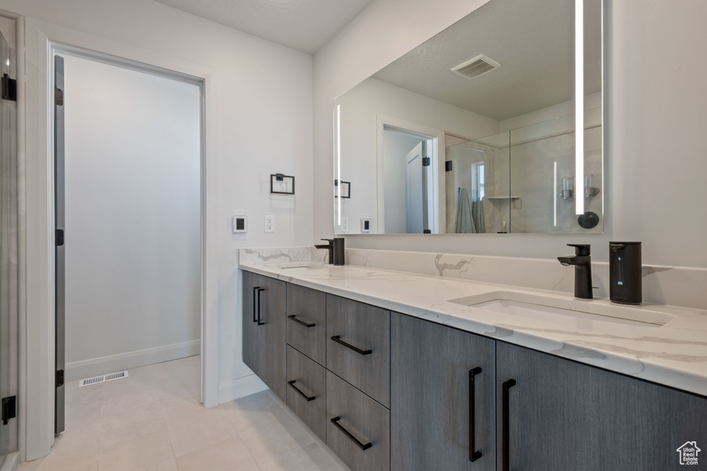 Bathroom with tile patterned floors, an enclosed shower, and vanity