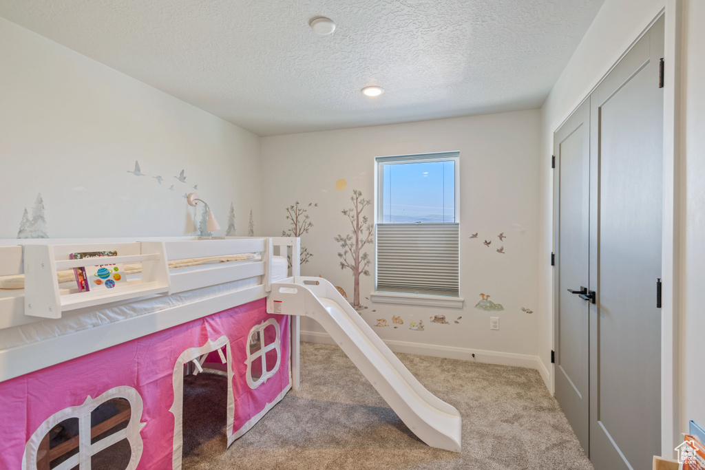 Bedroom featuring a textured ceiling and carpet