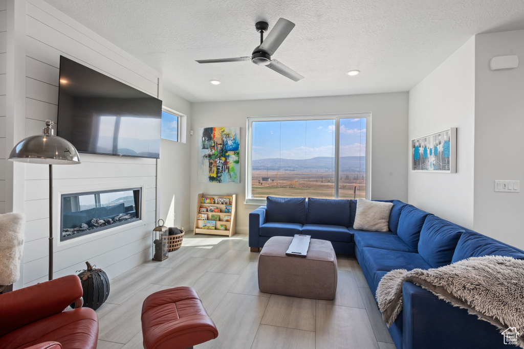 Living room with ceiling fan and a textured ceiling