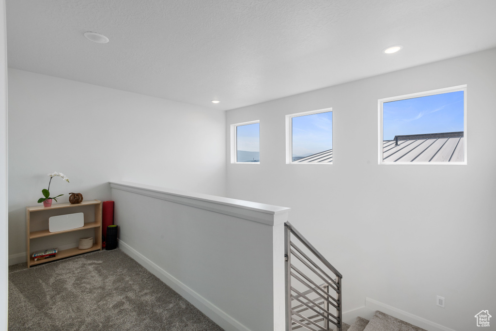 Hallway featuring dark colored carpet