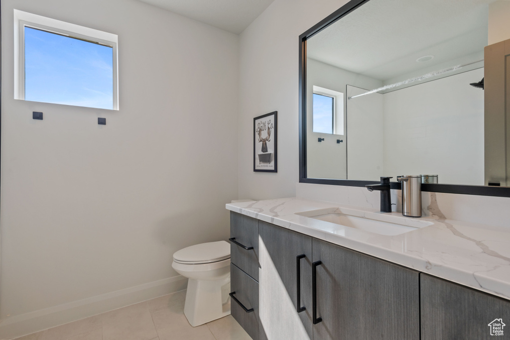 Bathroom with vanity, a shower, tile patterned flooring, and toilet