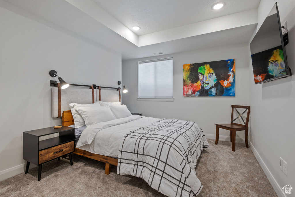 Bedroom featuring light carpet