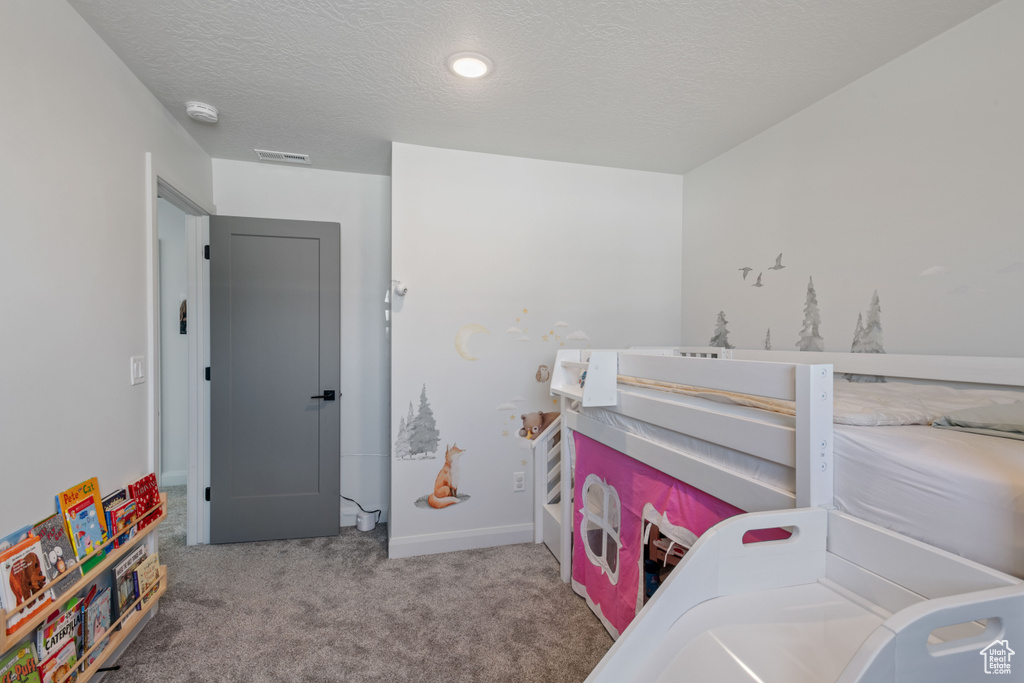 Bedroom featuring a textured ceiling and carpet flooring