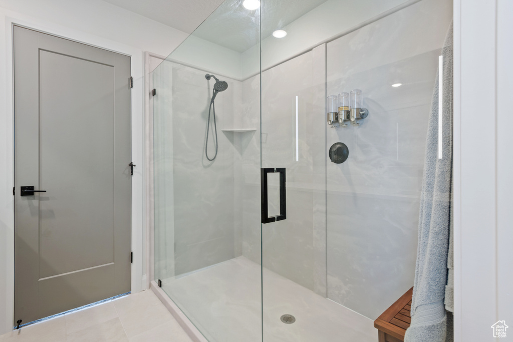 Bathroom featuring a shower with shower door and tile patterned floors