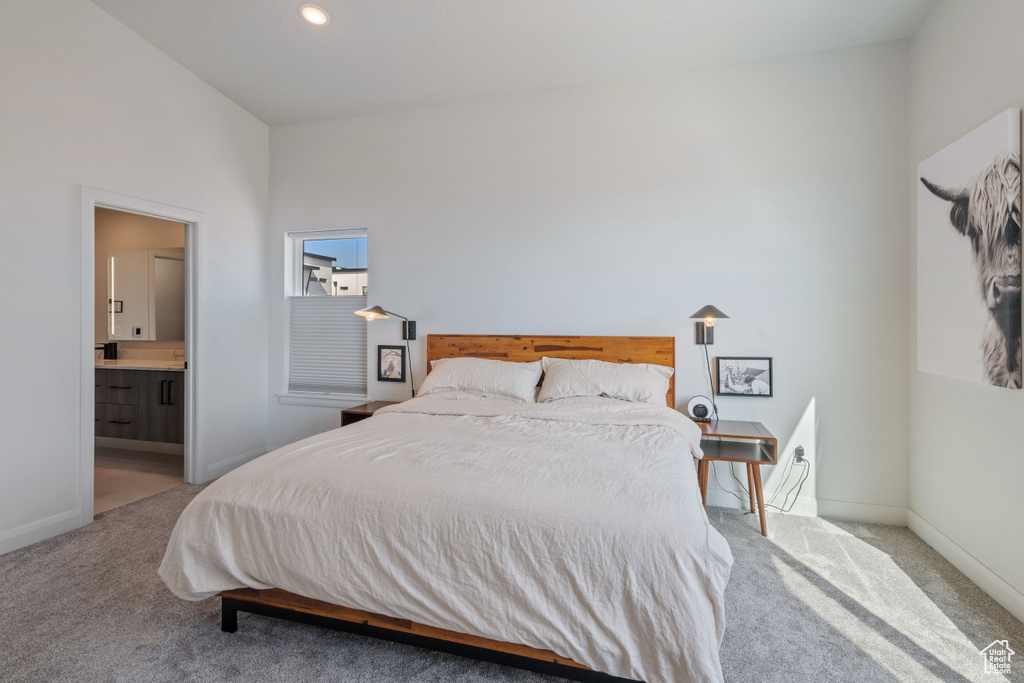 Carpeted bedroom featuring ensuite bath