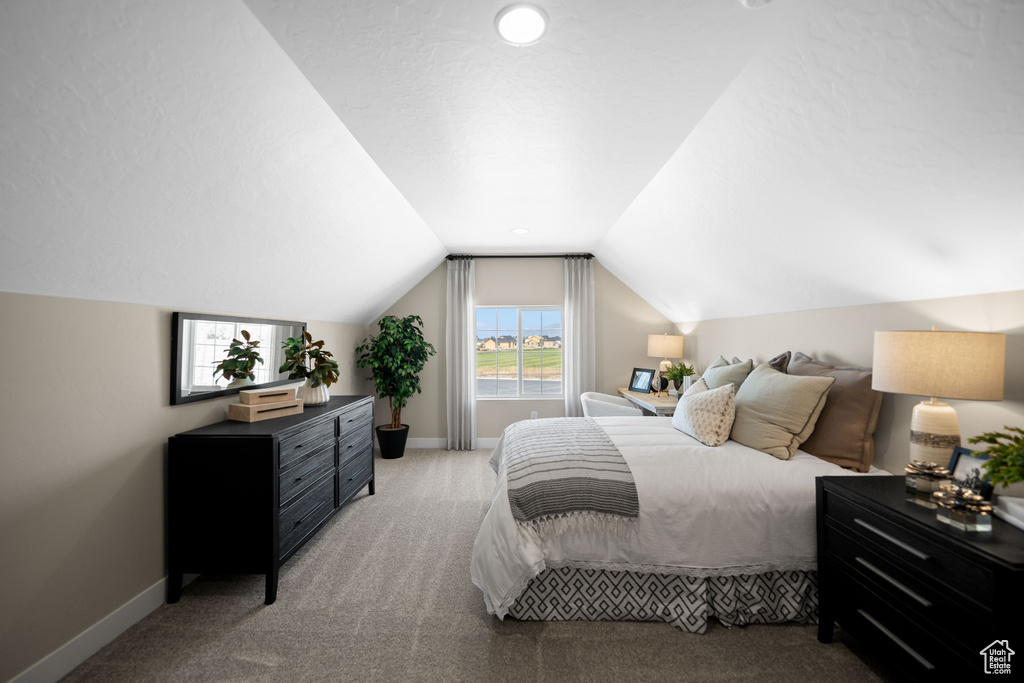 Bedroom featuring carpet floors and lofted ceiling