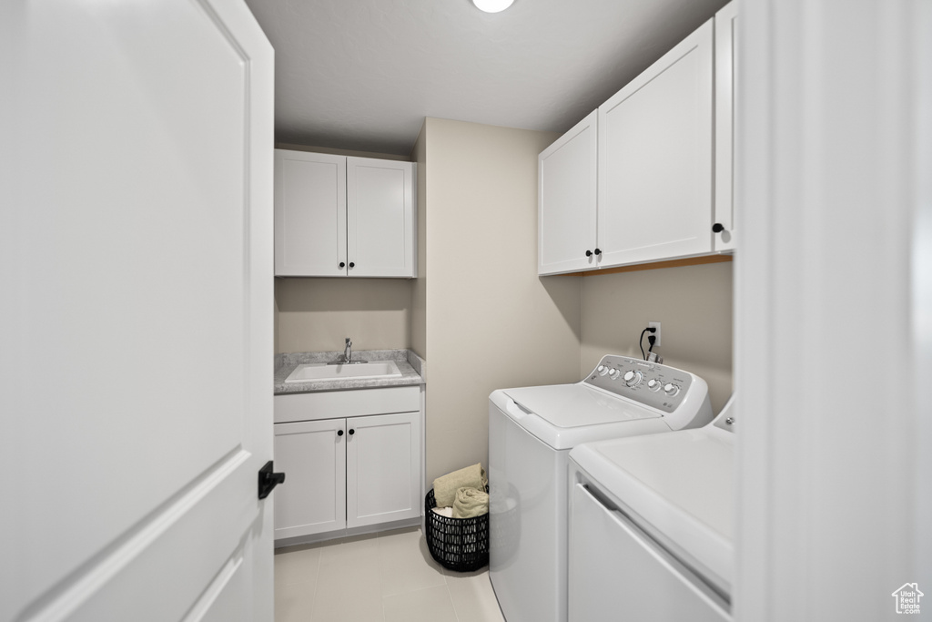 Laundry area with sink, cabinets, and washer and clothes dryer