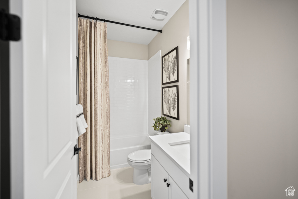 Full bathroom featuring shower / bath combo with shower curtain, vanity, and toilet