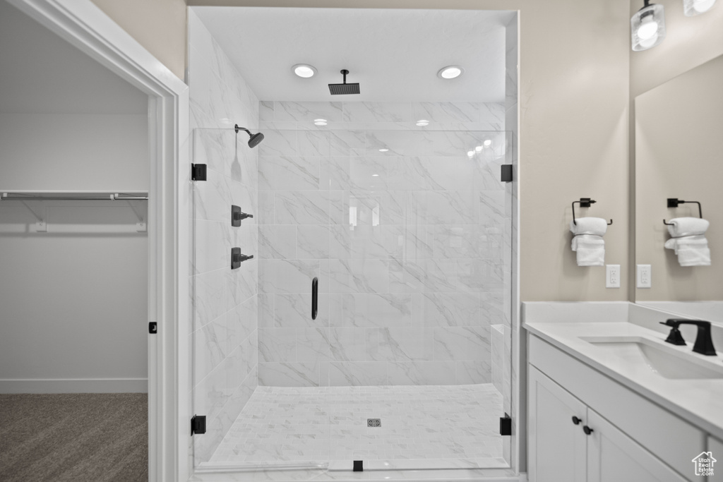 Bathroom featuring a shower with door and vanity