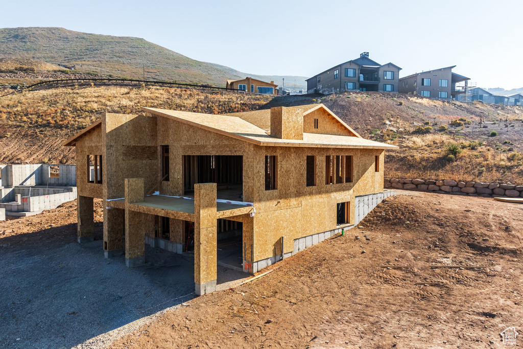 Back of property with a mountain view and a patio area