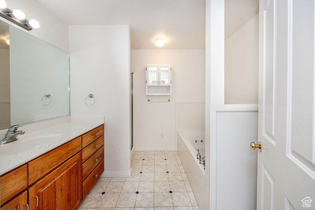 Bathroom featuring vanity, tile patterned flooring, and separate shower and tub