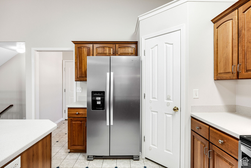 Kitchen with stainless steel fridge and light tile patterned floors