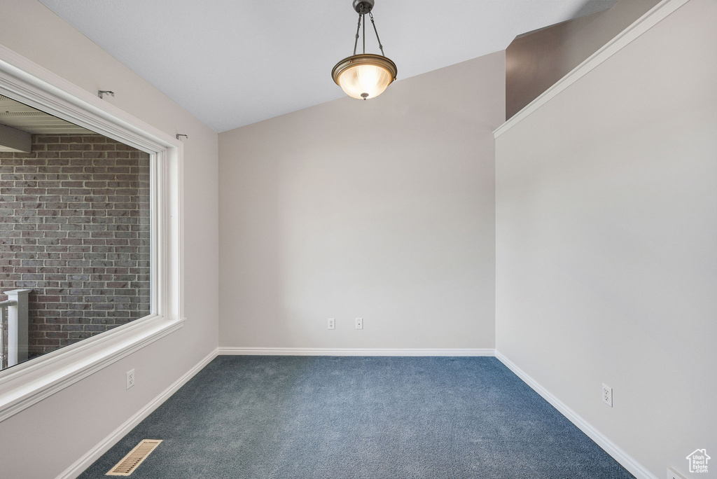 Carpeted empty room with vaulted ceiling