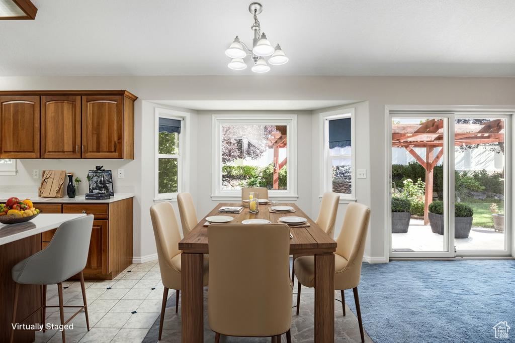 Tiled dining room featuring an inviting chandelier