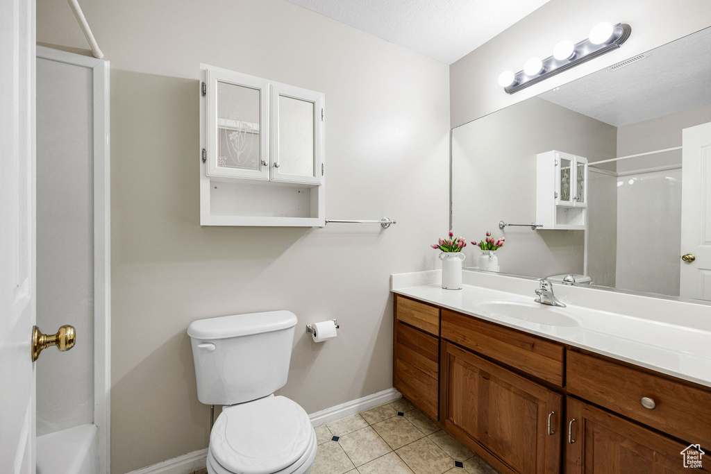 Full bathroom with shower / tub combination, vanity, toilet, and tile patterned floors