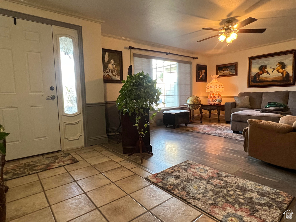 Entryway featuring wood-type flooring, ornamental molding, and ceiling fan