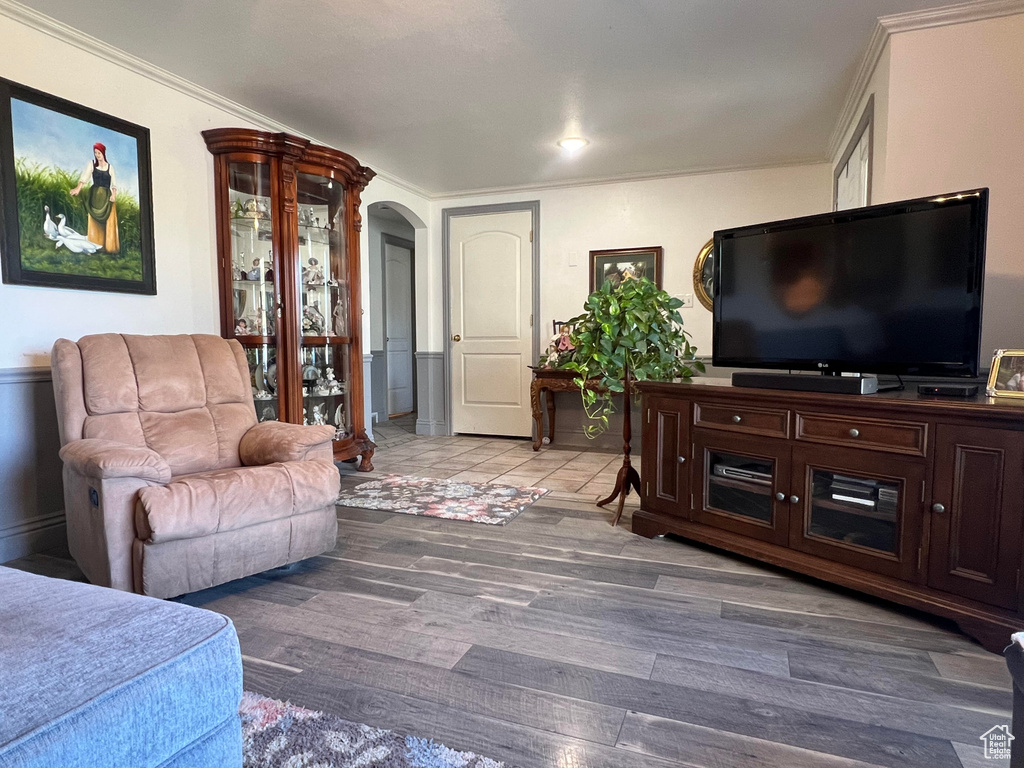 Living room with crown molding and hardwood / wood-style floors