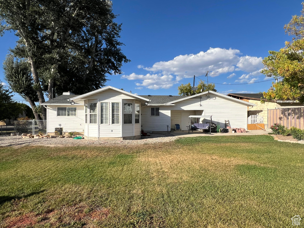 Back of house featuring a lawn and a patio area