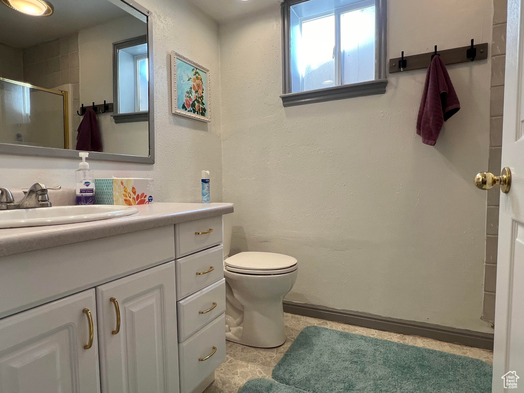 Bathroom with an enclosed shower, toilet, and vanity