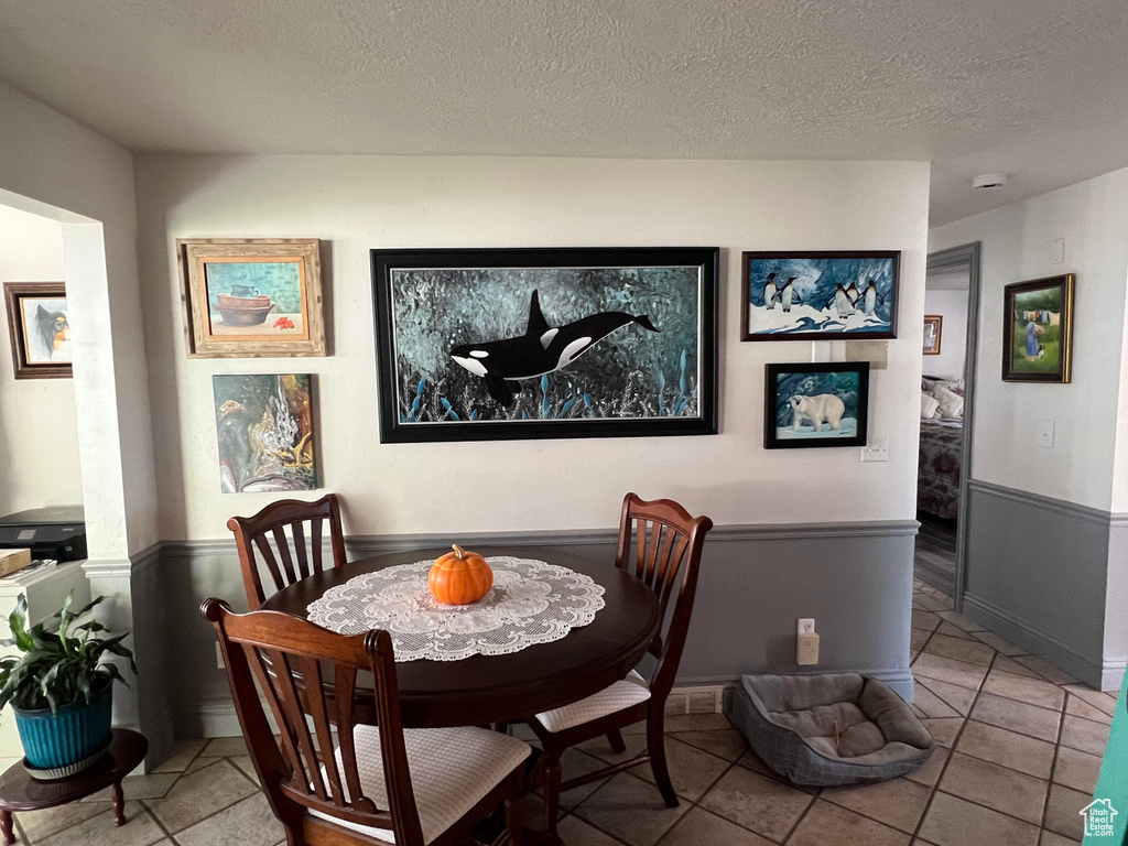 Dining room with tile patterned flooring and a textured ceiling