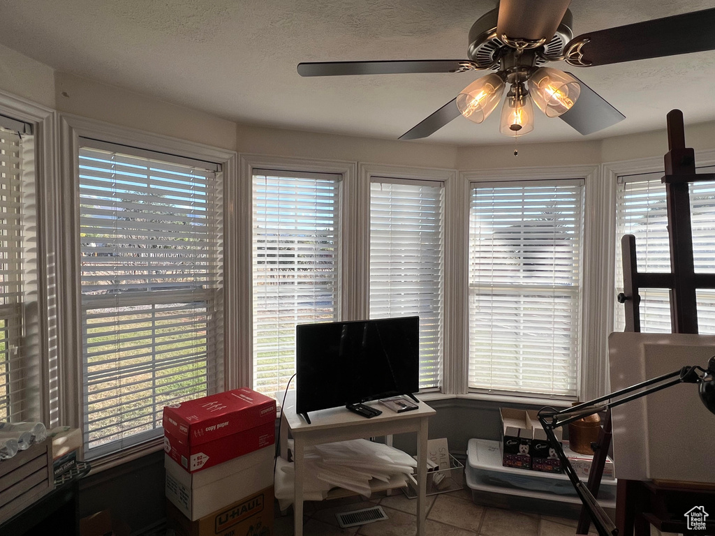 Office with ceiling fan and a wealth of natural light