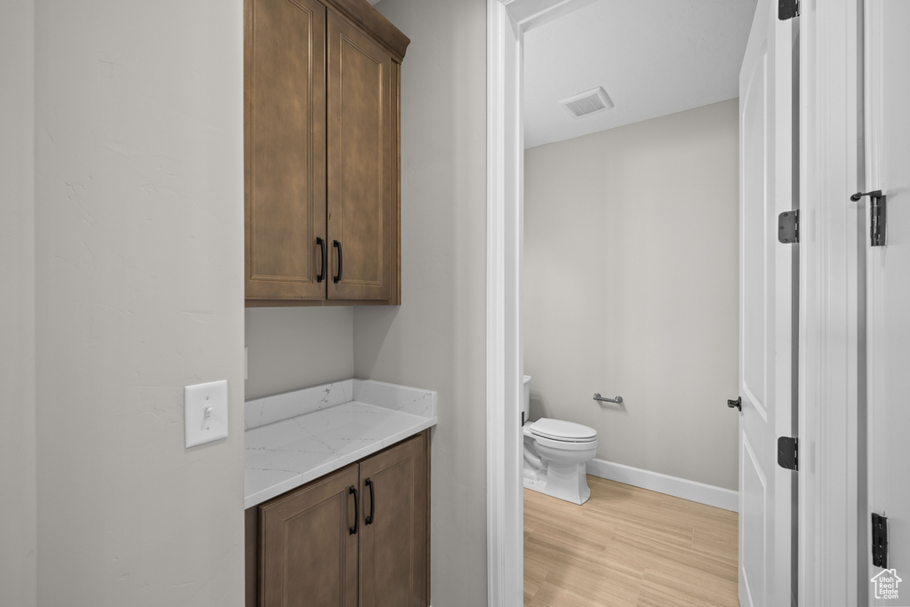 Bathroom featuring hardwood / wood-style floors and toilet