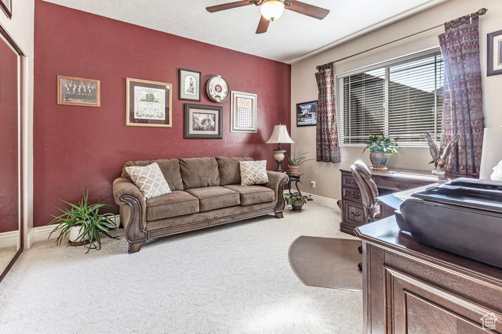 Carpeted office space featuring ceiling fan