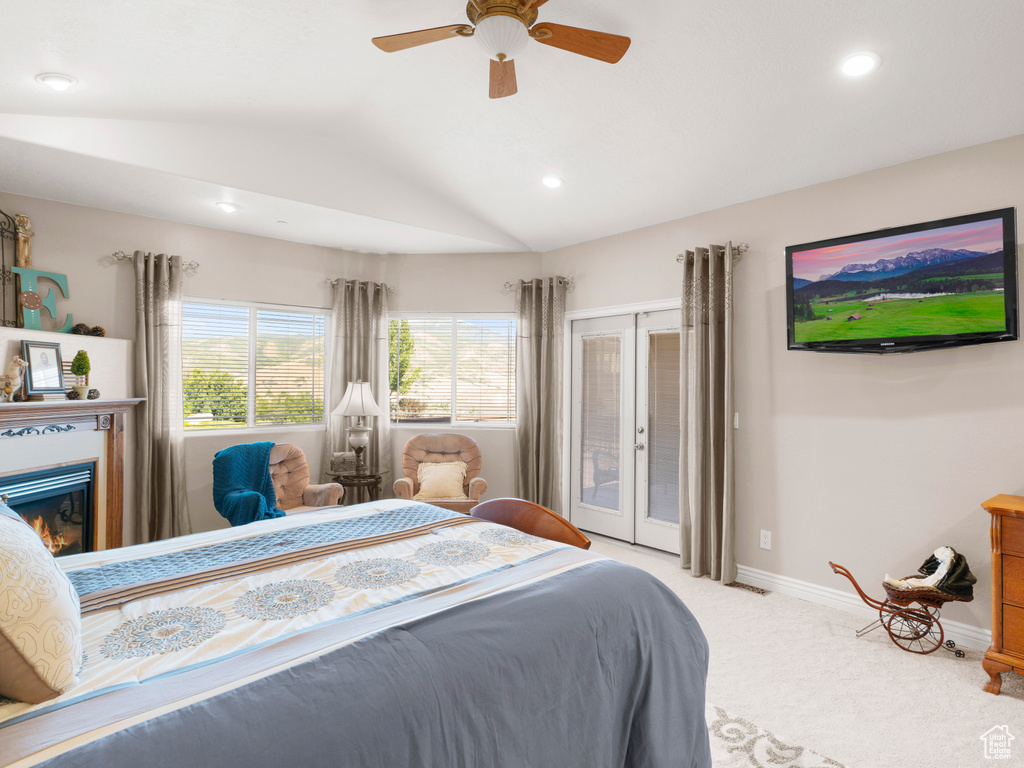 Bedroom featuring ceiling fan, access to exterior, light carpet, and vaulted ceiling